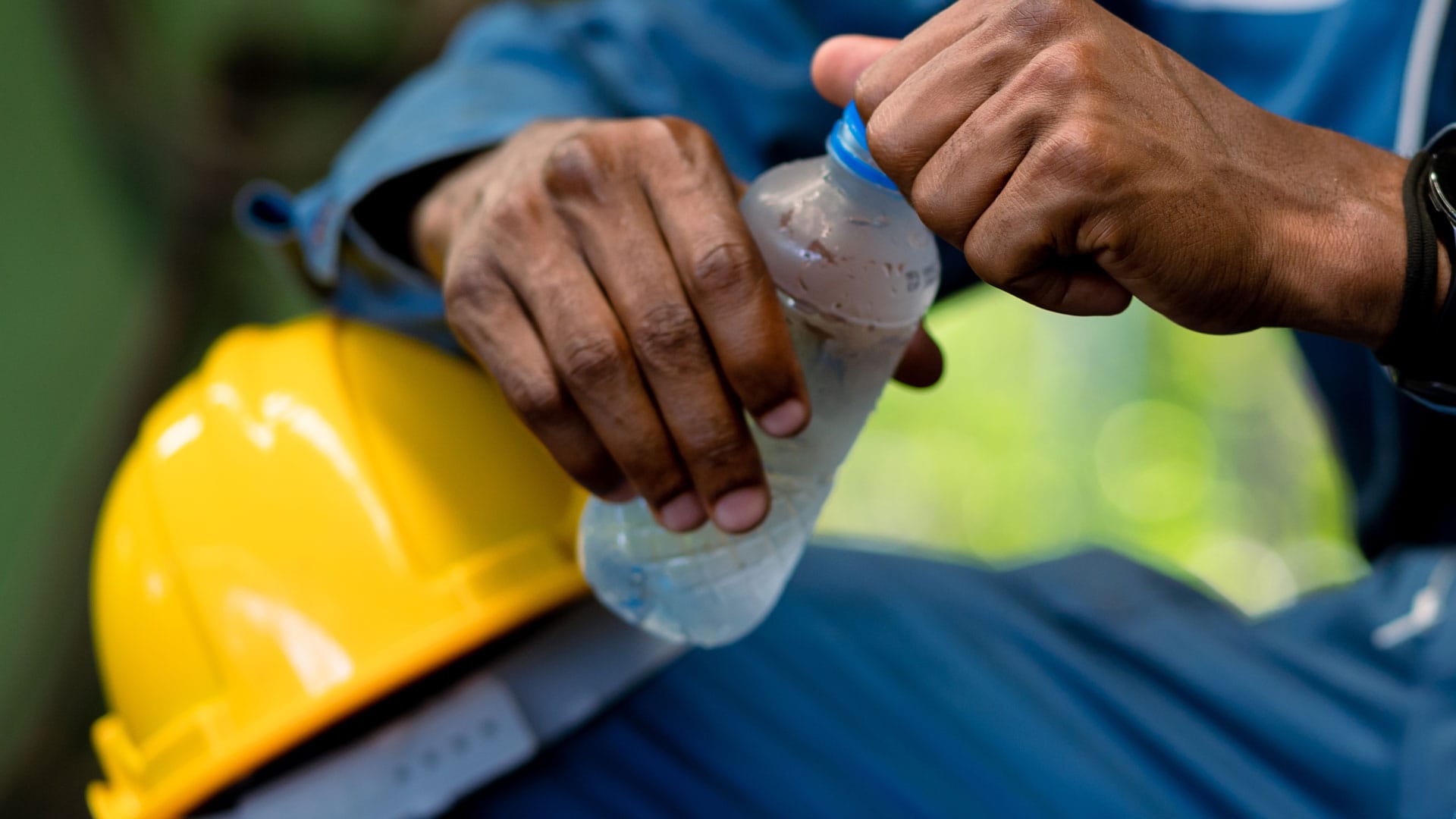 Worker drinking cold bottled water to stay hydrated.