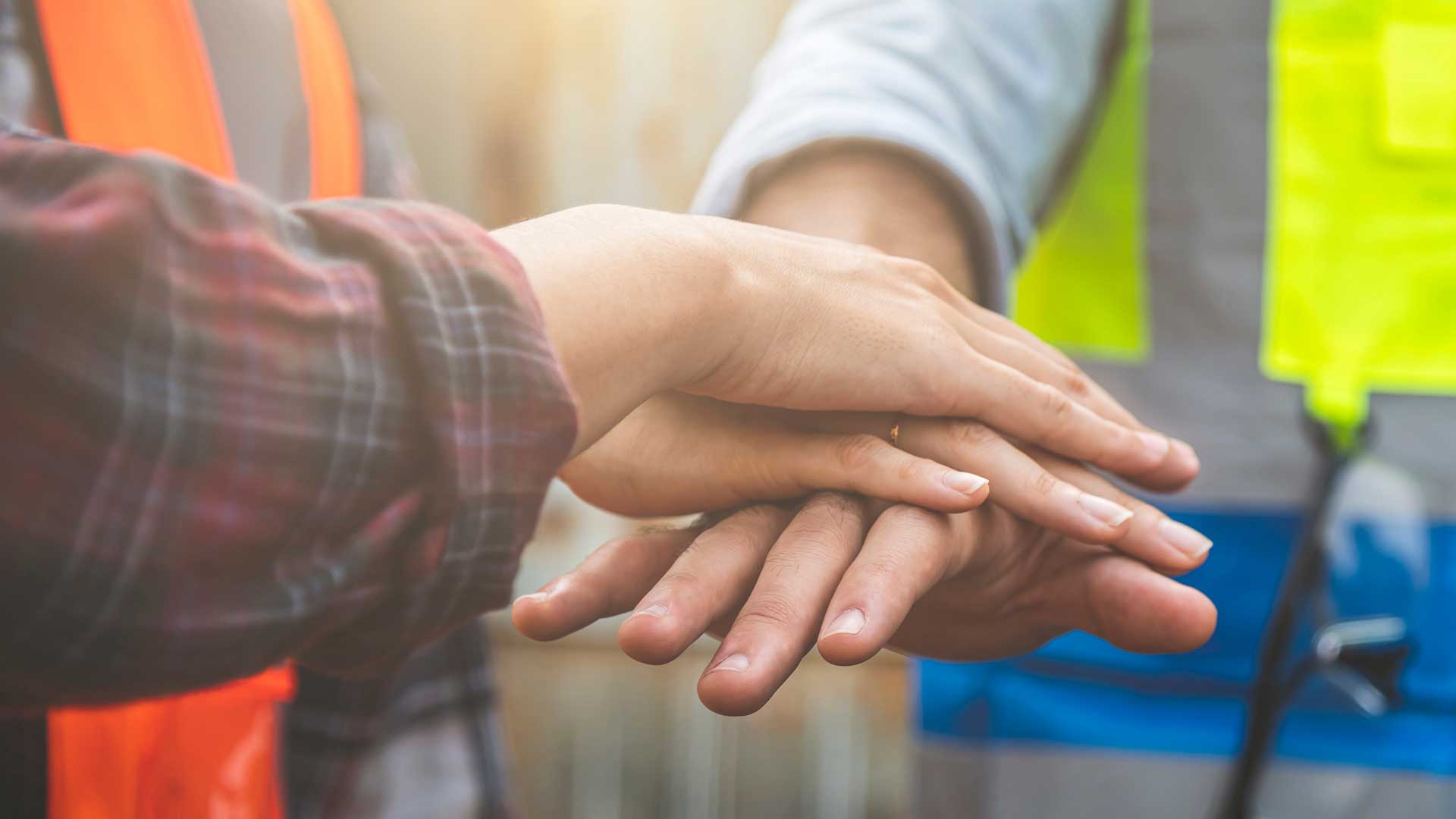 Several hands stacked together, suggesting teamwork.