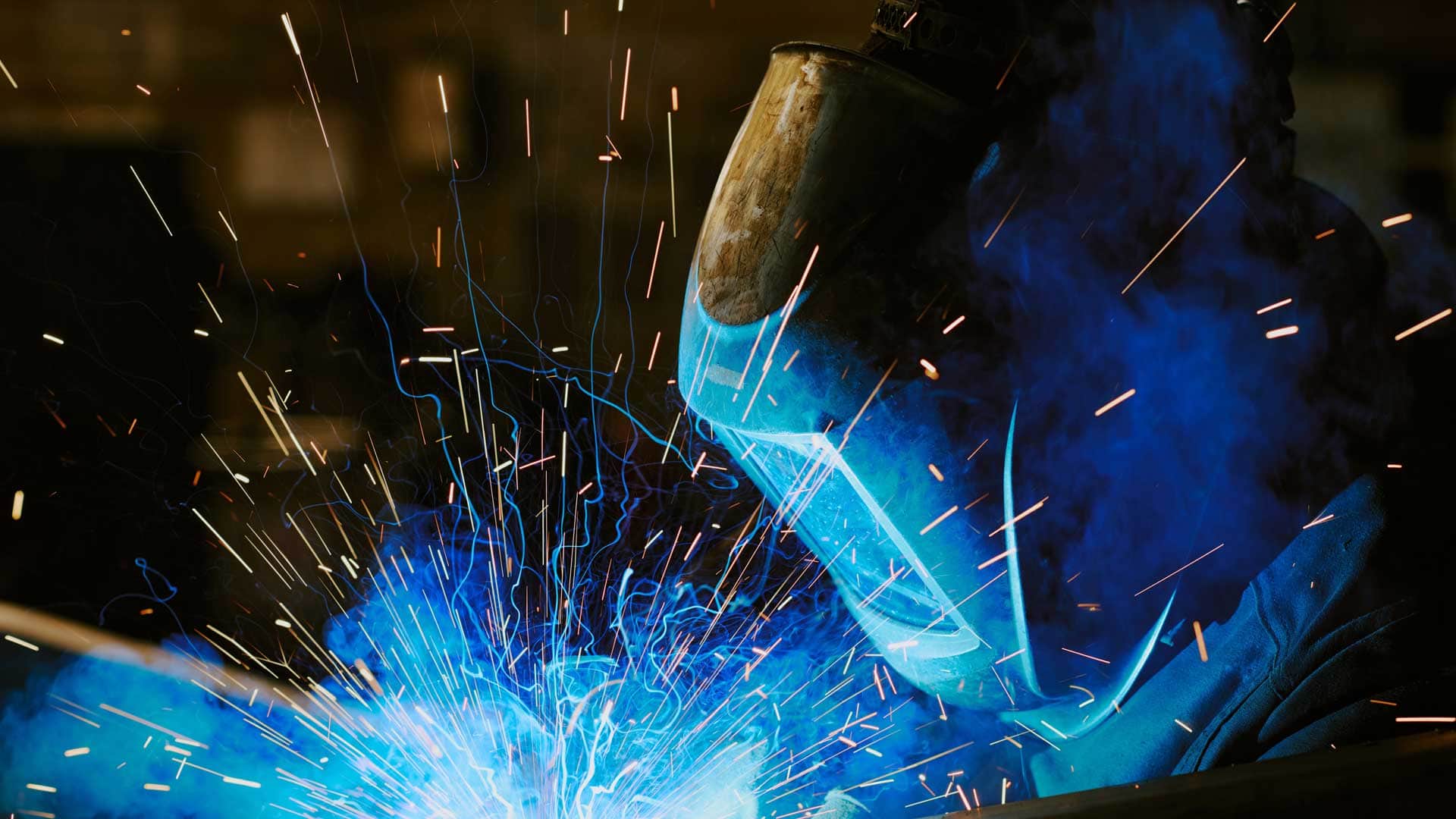 Welder wearing protective helmet.