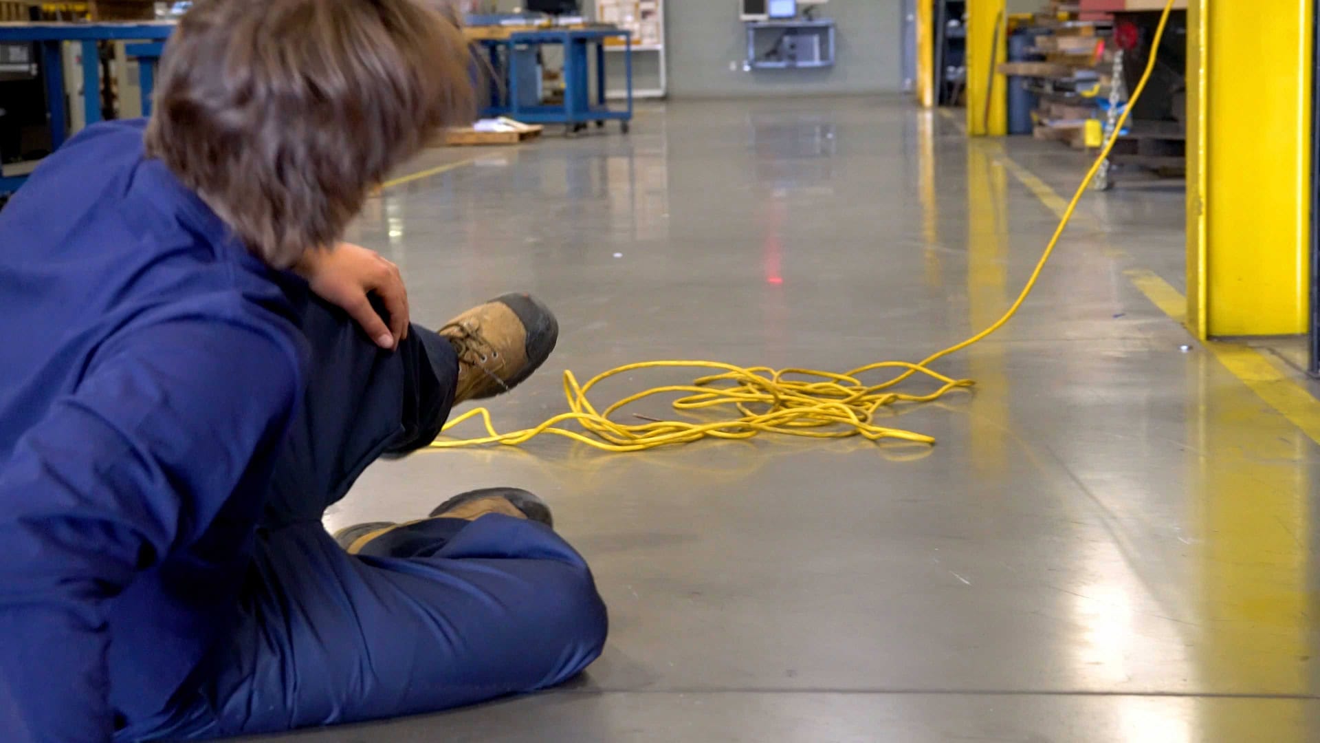Worker sitting on the floor after tripping over a tangled extension cord.