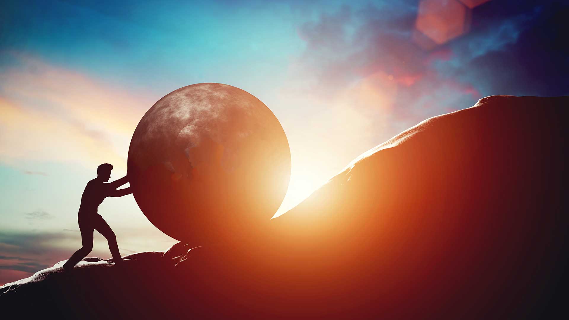 Man pushing boulder up mountain with sun rising in background.