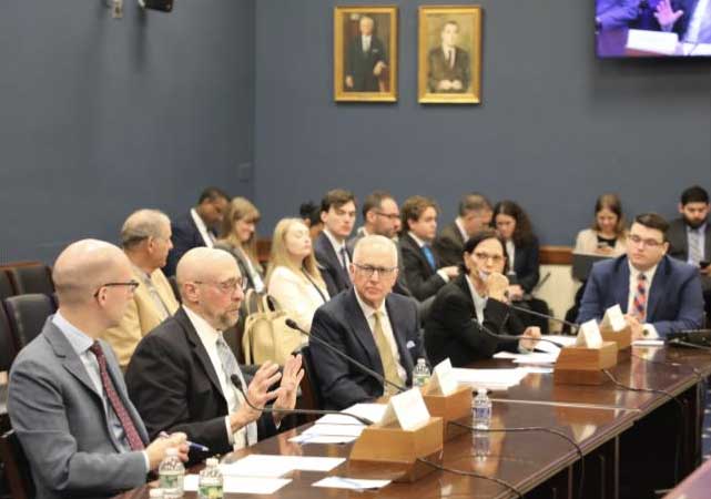 Industry representatives seated at a conference table providing testimony during a congressional hearing.