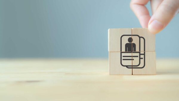 Hand placing wooden blocks with a customer icon to represent defining an ideal customer profile.