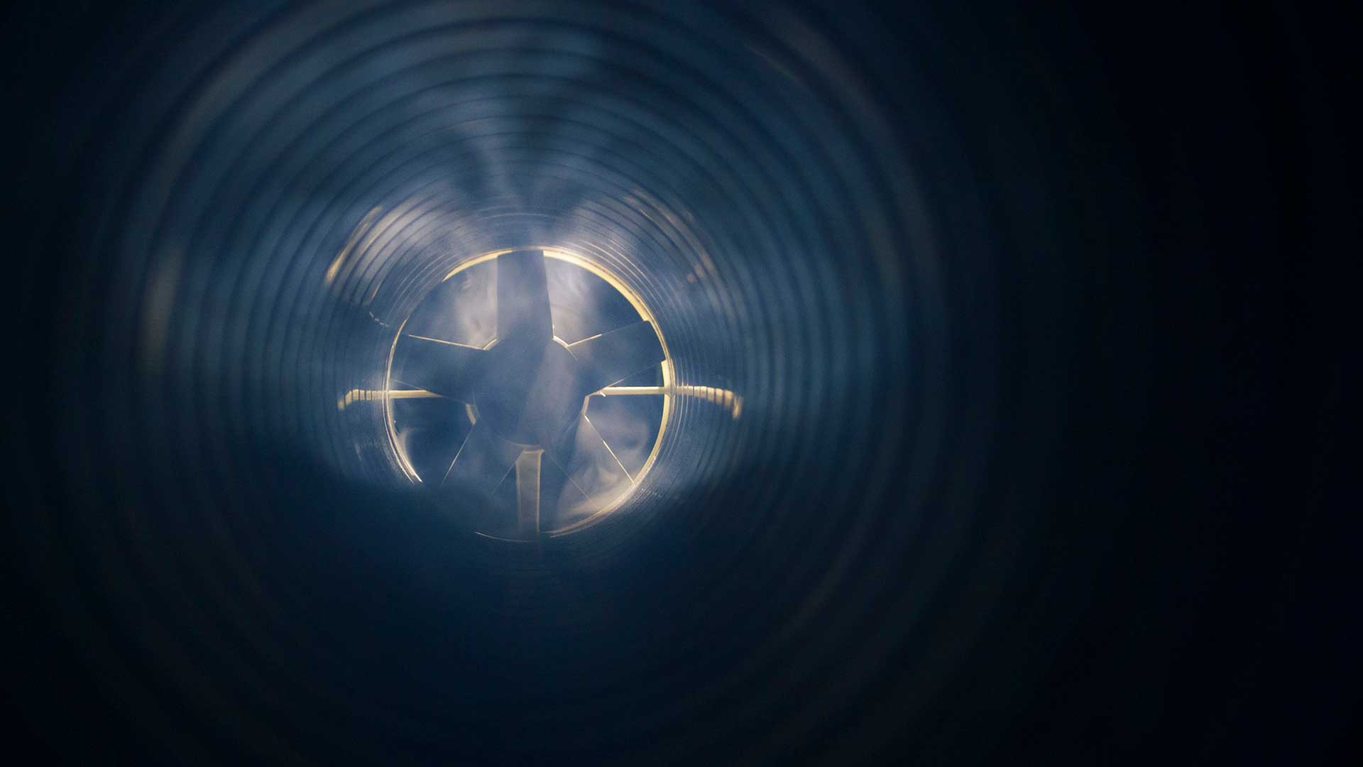 Industrial ventilation fan inside a steel duct used for airflow and exhaust control.