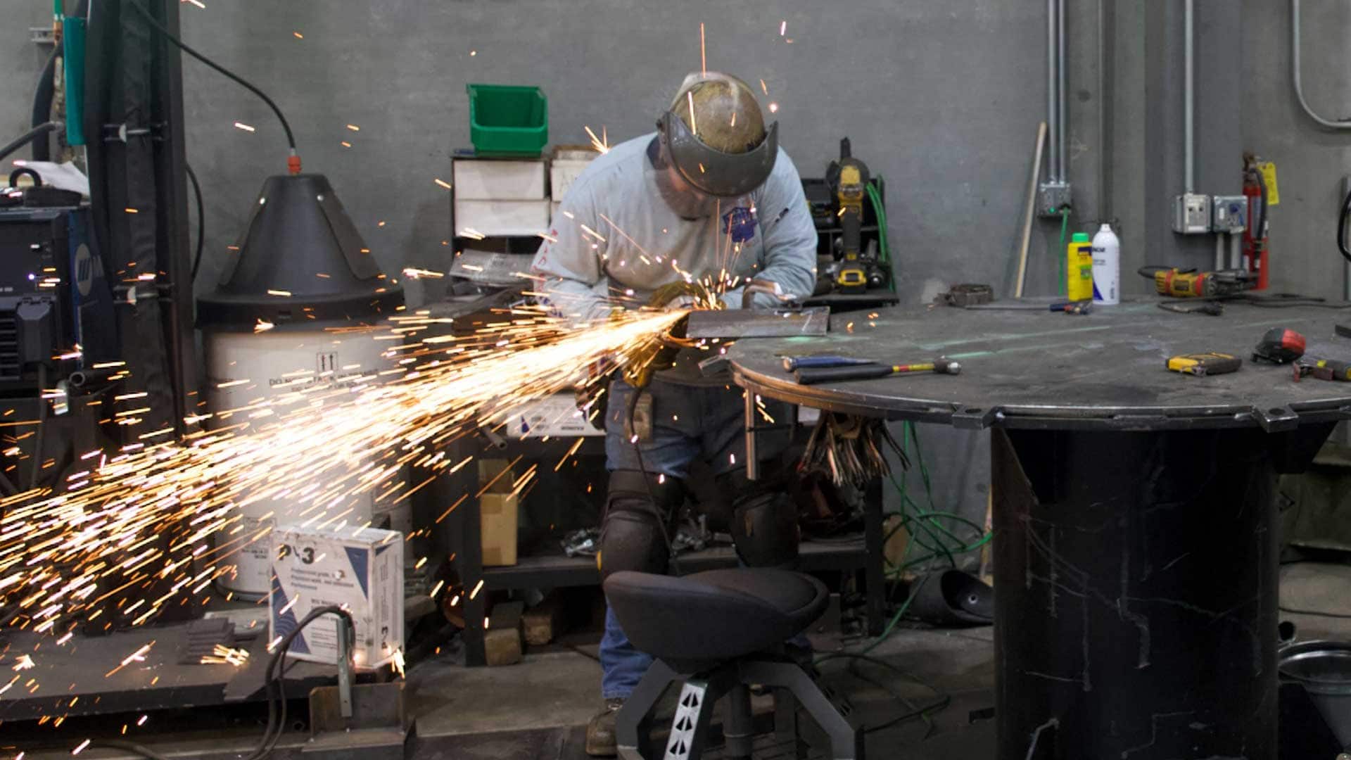Welder fabricating steel components in a manufacturing facility.